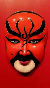 中国传统京剧脸谱红色背景上照片