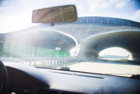 在公路上用重的太阳耀斑驾驶汽车