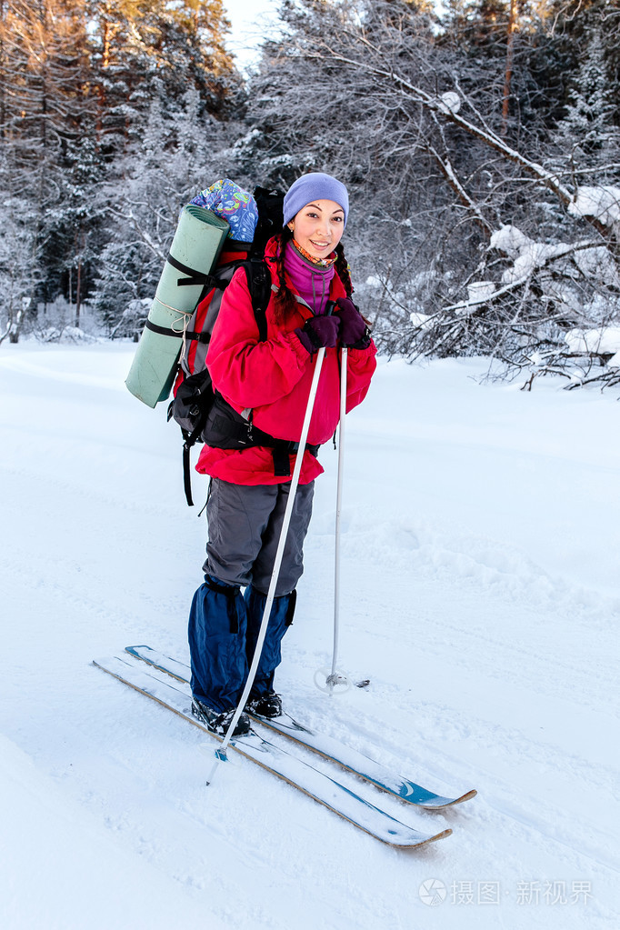 女人的徒步旅行者在冬天山在路上与在雪橇上,广管局