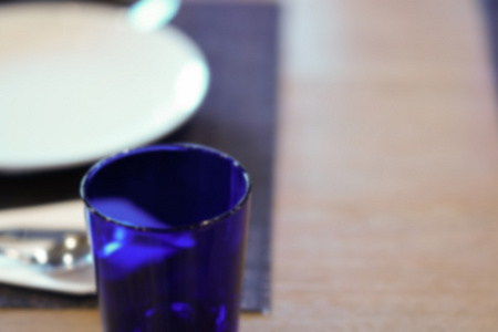 木桌上的盘子, 勺子, 叉子和蓝色玻璃, 模糊和 defoc