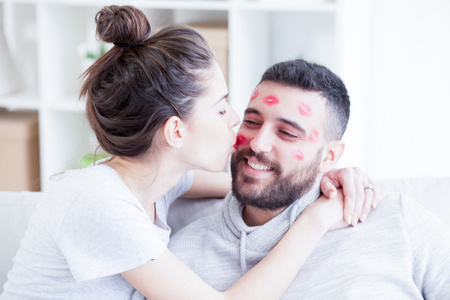 情人节的情侣.女人吻男人与他的脸,浅景深的红色唇膏照片