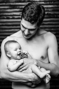年轻的父亲喂养他的宝贝 daughter.baby father.black 和白手中微笑的女孩