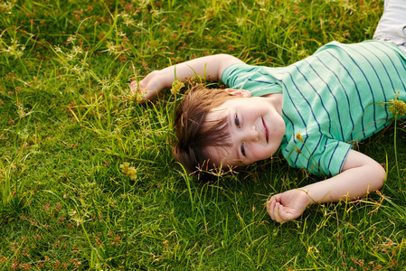 小男孩躺在绿草