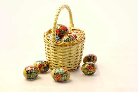 在白色背景上的柳条篮子中的复活节彩蛋