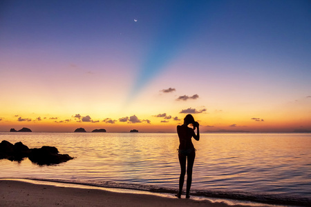 在苏梅岛日落剪影年轻女人站在海滩上看日落的热带岛屿苏梅岛,泰国