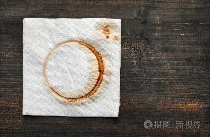在黑暗的木桌上用过的纸餐巾