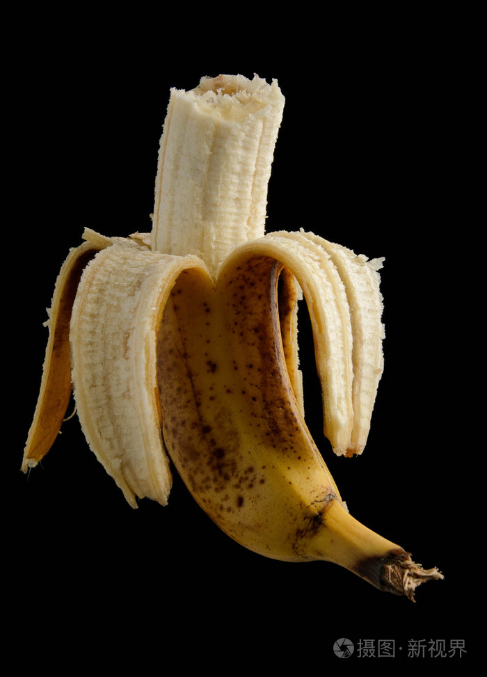 孤立在黑色的一半去皮斑点的香蕉