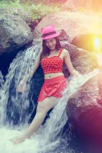 亚洲美丽年轻的女孩站在瀑布