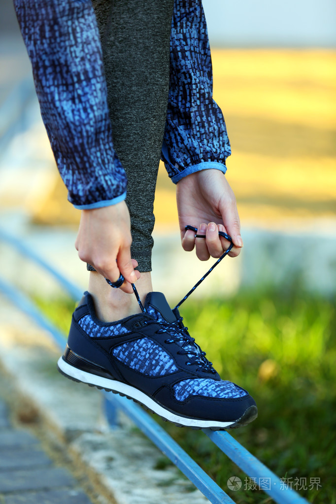 女人在运动服绑鞋带