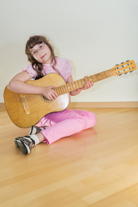 年轻小女孩在玩吉他