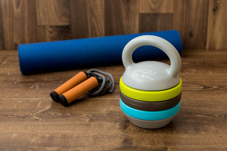 可调的壶，跳跃绳和 fitnes 的垫子上木制的背景。重量为体能训练的