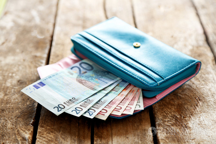 木制的桌子上欧元纸币打开蓝色钱包
