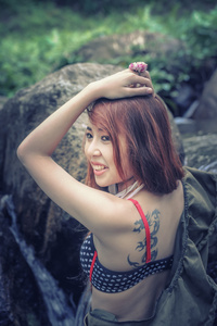 亚洲美丽年轻的女孩站在瀑布