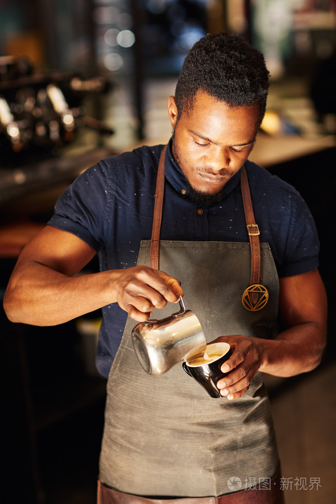 咖啡师用卡布奇诺倒奶