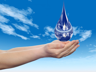 概念或概念的蓝色水或液体滴在两个女人手中落在蓝蓝的天空背景上