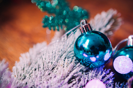 云杉分行在雪紫蓝色和白色圣诞球上深色木制背景