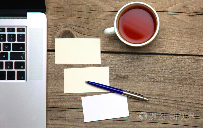 木制办公桌子上的钢笔和茶杯空白名片