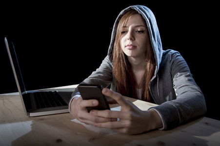 青少年黑客女孩在网上使用手机