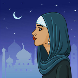 美丽的穆斯林妇女,披着披肩,在夜城的背景下照片