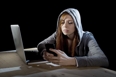 青少年黑客女孩在网上使用手机