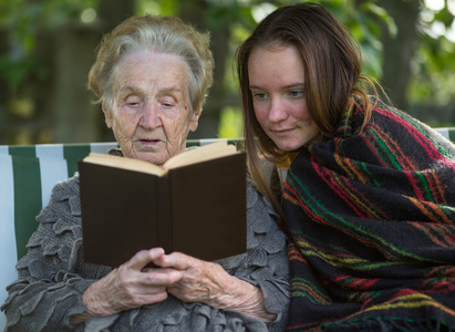 老妇人对她的孙女看书