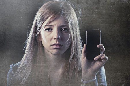 担心的青少年持有手机作为互联网网络欺凌柄虐待的受害者