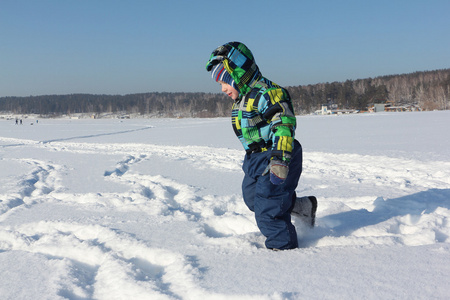 孩子在冬天在雪地上奔跑的颜色夹克
