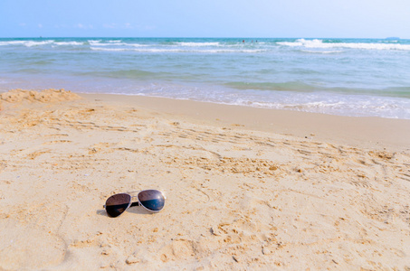 沙滩上的墨镜旅行和放松夏季的概念