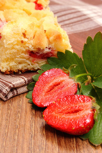 新鲜草莓用树叶和一块酵母蛋糕