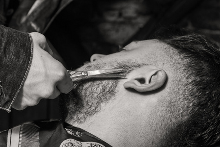 发型男士理发店。男士美发师理发师。用剪刀理发削减客户端
