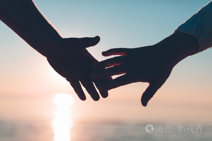 在天空和大海背景上双手到达剪影