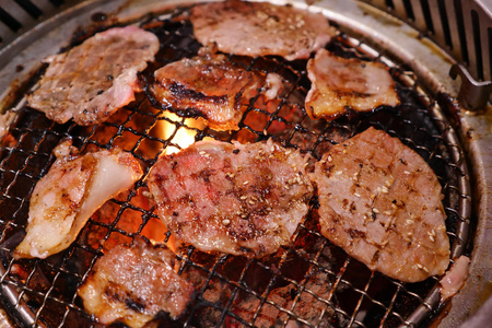 猪肉在火炭上烤。这种食品是韩国或日本烧烤的风格