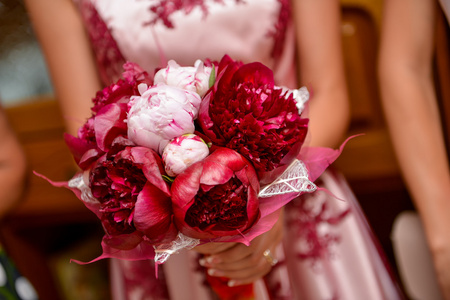 新娘紧握着一束红色的鲜花