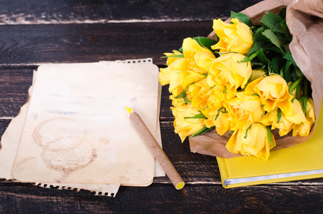 黄玫瑰，复古纸 笔记本和铅笔上老木背景与框架。可用空间为您的文字的