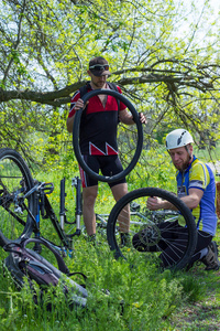 男人在夏天修复车轮在山地自行车的性质