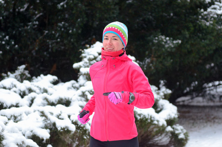 冬天在公园跑步 幸福的女人跑慢跑在雪 户外运动和健身概念