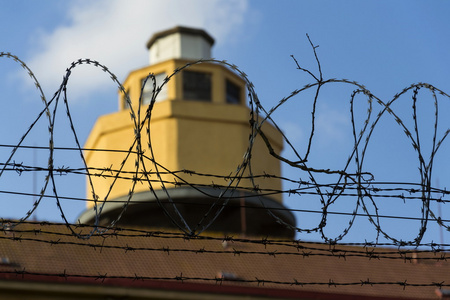 监狱围墙周围有刺铁丝网背后的守卫塔