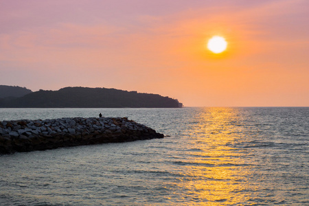 在兰卡威岛上观看日落的岩石上坐的人
