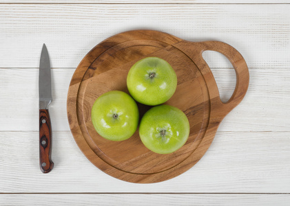 成熟多汁的苹果躺在木板上用小刀在它旁边在顶视图
