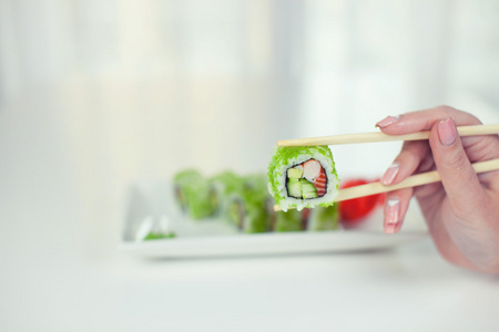 筷子的寿司卷部分以表餐厅  吃寿司卷用筷子的特写