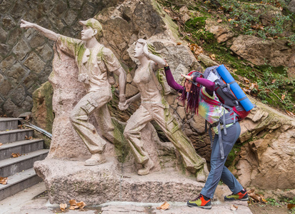 年轻的女士徒步旅行者背包走在山