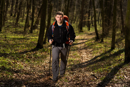 男性的徒步旅行者寻找到的一侧走在森林
