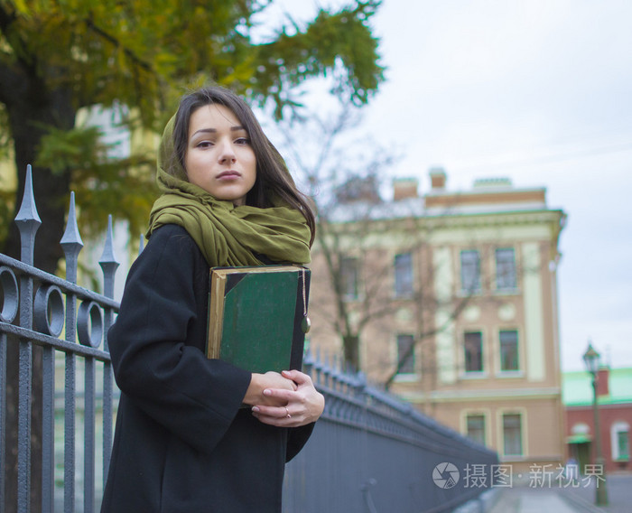 拿着一本书在街上走的那个女孩