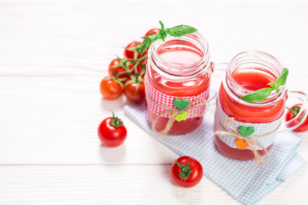 番茄汁和新鲜的西红柿，在白色的木制背景