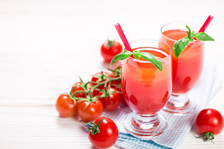 番茄汁和新鲜的西红柿，在白色的木制背景