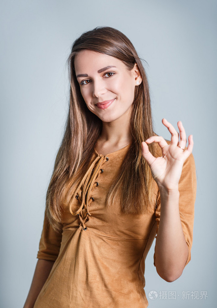 年轻漂亮的女人显示ok的手势