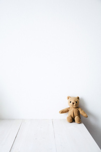 坐在白色背景上的桌子上的玩具熊