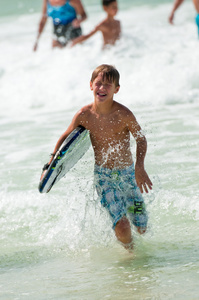 年轻可爱的男孩，在海洋海滩中运行
