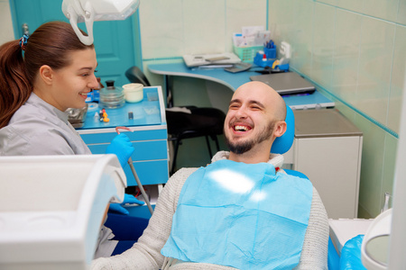 牙科医生在治疗期间与病人有乐趣