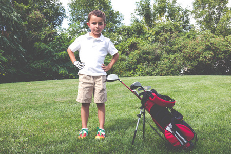 他在球道上的高尔夫球袋小男孩高尔夫球手